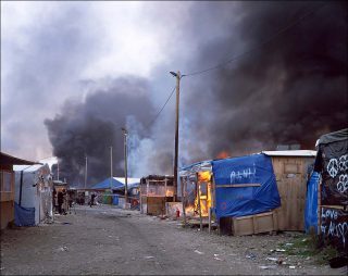 Bruno Serralongue, Un incendie ravage le « bidonville d’Etat » pour migrants au moment de son démantèlement, Calais, 26 octobre 2016, 2006-2018.